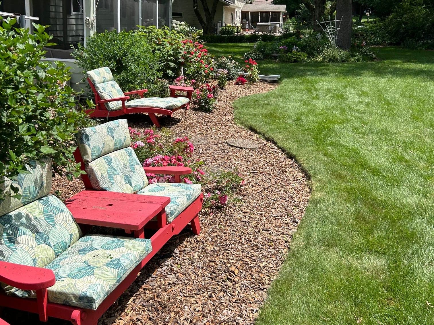 Backyard seating area beside a freshly edged mulch bed